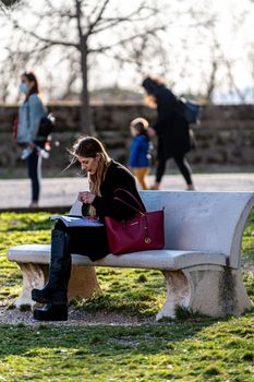 terni,italy march 25 2021:girl sitting at the park reading a book