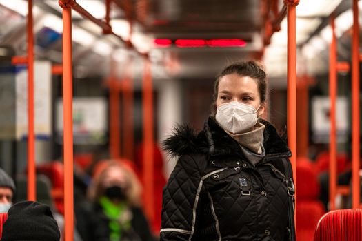 woman in public transport with a respirator on her face. coronavirus epidemic.