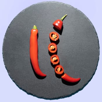 Some hot red chillies on a black stone plate