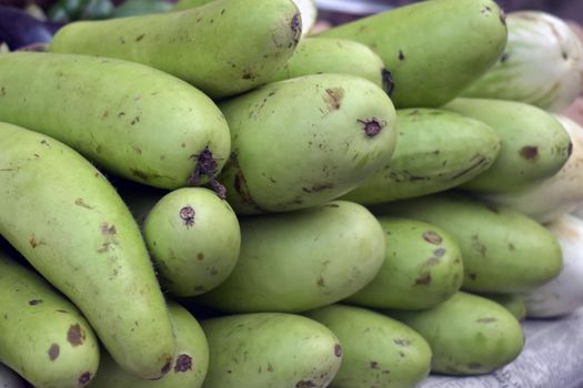 A closeup shot of a pile of bottle gourd in the market place