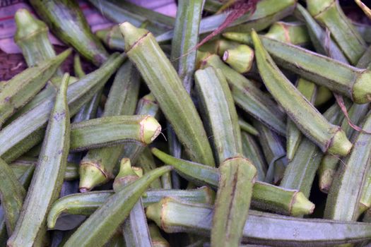 A closeup shot of a pile fresh okra of in a market place