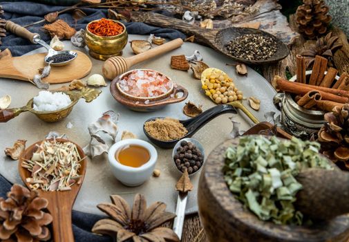 Various spices and herbs in rustic style with honey on balck background. Natural herbs medicine, Organic herbal and healthy concept, Selective focus.