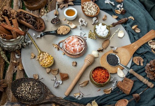 Various spices and herbs in rustic style with honey on balck background. Natural herbs medicine, Organic herbal and healthy concept, Selective focus.