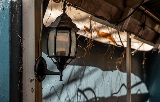 Street lamp on a steel pole at the blue brick wall.  Lamps in a narrow alley.