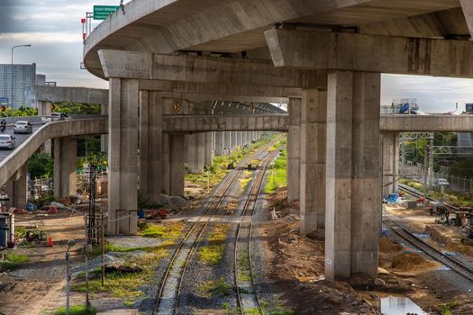 Bangkok, Thailand - Jun 19, 2020 : The railway under tollway. Urban landscape with railway. Colorful of environment with sunset, trees and green grass. Railway junction. Evening in summertime.
