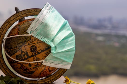 Bangkok, Thailand - Jun 25, 2020 : The globe is wearing a disposable medical mask. Concept of prevent spread of corona virus covid-19. Everyone should wear mask in public. Coronavirus pandemic, World quarantine, Selective focus. Copy space.