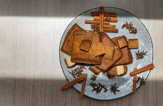 Traditional black herb tofu on ceramic plate. Culinary vegan and vegetarian eating. Top view.