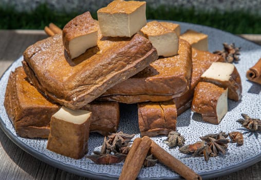 Traditional black herb tofu on ceramic plate. Culinary vegan and vegetarian eating.