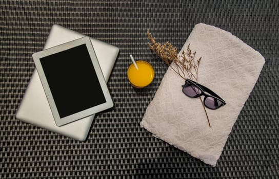 Relaxing moment by the pool. Take a break from working on laptop and tablet and enjoy the fresh orange juice under the sun for a refreshment. Outdoor swimming pool background. leisure activity.