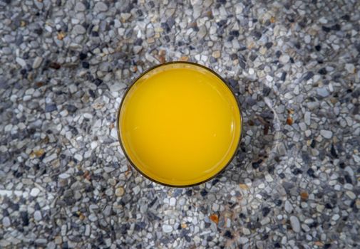 A glass of fresh orange juice with flower for a refreshment on stone background. leisure activity.