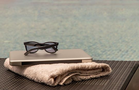 Relaxing moment by the pool. Take a break from working on laptop for a refreshment.  Outdoor swimming pool background. leisure activity.