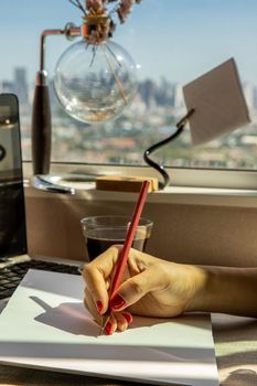 Hand of business woman writing on paper at her workstation. business concept.