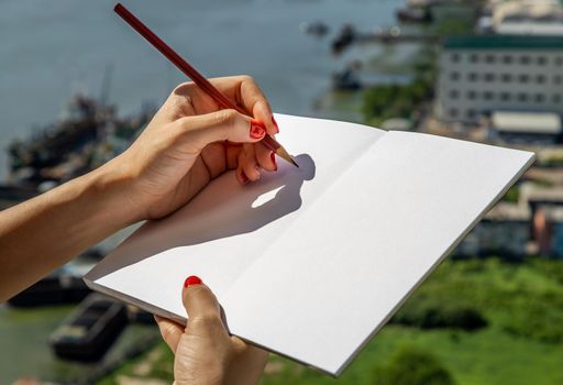 Hand of business woman writing on paper at her with city views. business concept.