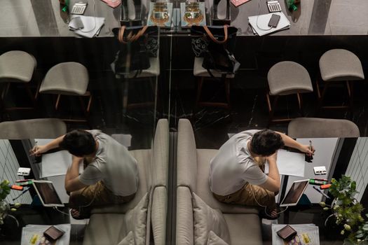 Bangkok, Thailand, Jul 04, 2020 : Top view of a young man works or study online on the black table in co working space. Digital nomad working in co working space, modern IT lifestyle with work life balance concept.