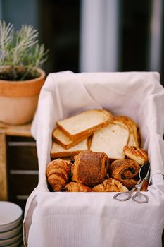 Close-up of sliced bread, rolls and croissants in a bread basket. High quality photo