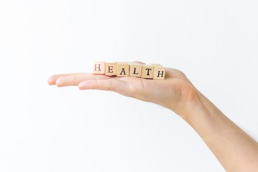 Hand holding wooden letters for health concept. White background.
