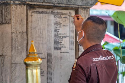 Bangkok, Thailand - Jun 19, 2020 : Temple staff is writing the donator name on the wall.