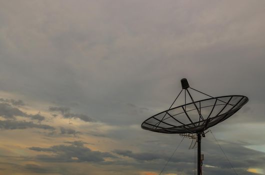 Black Satellite Dish Antenna Receiver Against on Blue Sky background for Communication and Media Industry, Symbolizing Global Communications. Free copy space for text, Selective focus.