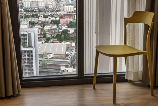Panoramic windows and single chair in simple room. Selective focus.