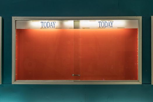 Empty frame of movie posters with spotlight on wall at old standalone movie theatres.