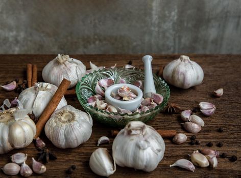 Garlic bulbs and Garlic cloves with Herbs spices, Cinnamon, Star anise and Pepper grain on Wooden rustic table. Copy space Concept of healthy food. Top view, Selective focus.