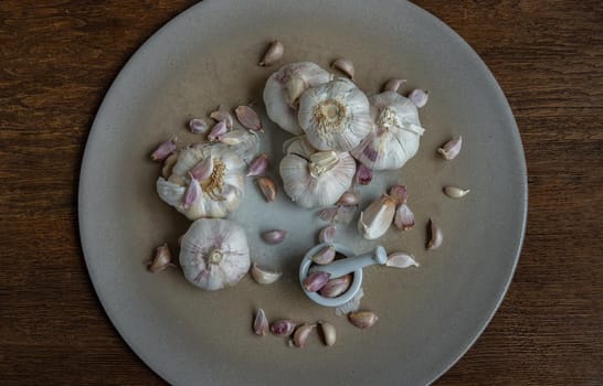 Garlic bulbs and Garlic cloves in Ceramic plate on Wooden rustic table. Copy space Concept of healthy food. Top view, Selective focus.