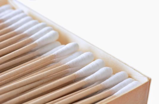 Closeup of the box full of ecological recyclable cleaning cotton swabs from recycled paper. It used for better environmental conservation. Cotton swabs on white background.