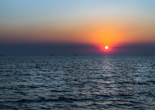 Beautiful sunset over a calm sea with a blue and orange glowing sky. Space for text, Selective focus.