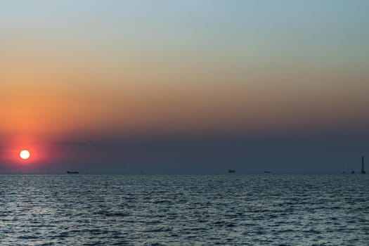 Beautiful sunset over a calm sea with a blue and orange glowing sky. Space for text, Selective focus.