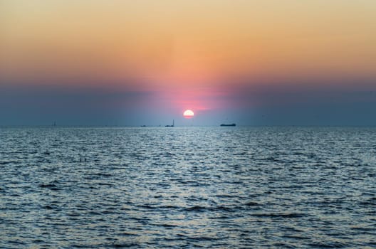 Beautiful sunset over a calm sea with a blue and orange glowing sky. Space for text, Selective focus.