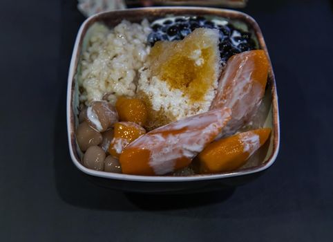 Traditional taiwanese iced dessert. Include Taro balls, Sweet potato balls, Barley with Shaved Ice and Boba Topping Served with Fresh milk in Earthenware bowl. No focus, specifically.