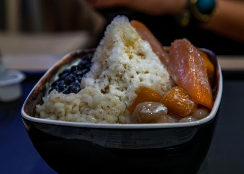 Traditional taiwanese iced dessert. Include Taro balls, Sweet potato balls, Barley with Shaved Ice and Boba Topping Served with Fresh milk in Earthenware bowl. No focus, specifically.
