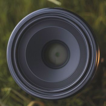 Macro camera lens in grass. High quality macro photo.