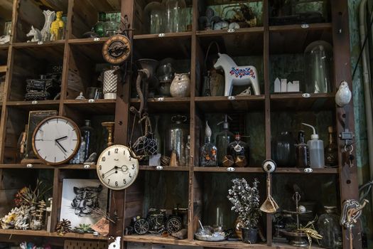 Bangkok, Thailand - Jun 26, 2020 : Wall clocks and Collectibles on handmade wooden rustic wall shelf in Living room Vintage style. Selective focus.