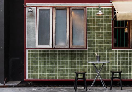 Table and wooden chairs in front of a traditional Chinese food shop. Concept and design front of Chinese retro style. No focus, specifically.