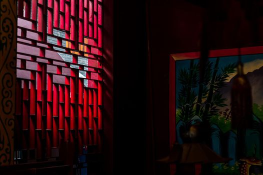 Bangkok, Thailand - Aug 01, 2020 : Light shines through the vent shade in the Chinese shrine's. Selective focus.