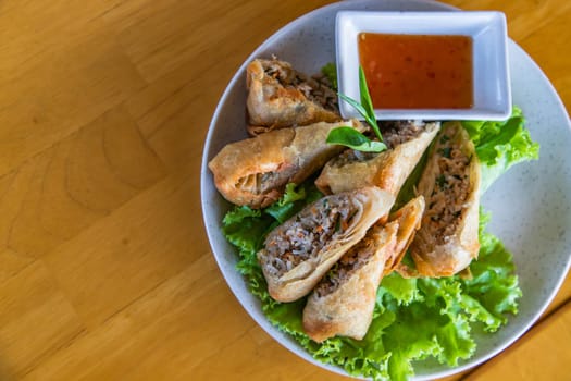 Fried traditional spring rolls food with sweet sauce in a white plate. Top view, Cope Space, Selective focus.