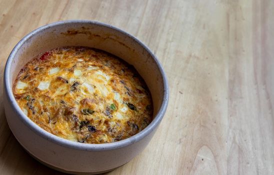 Baked eggs omelet on the wooden tray. Selective focus.