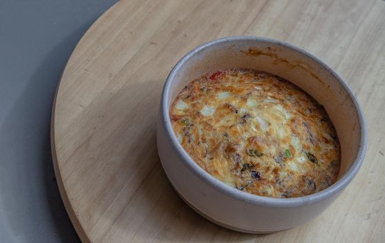 Baked eggs omelet on the wooden tray. Selective focus.