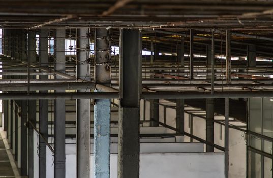 The structure inside the warehouse with light pole. Old structure in old building indoor. Selective focus.
