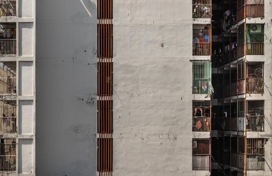 Side of the multi-storey old apartment building with balconies and old balustrade in bangkok city. Selective focus.