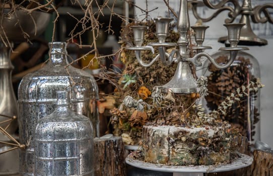 Antique candlestick and Dry plant, Dried flowers, Pine cones with Glass bottle Decorate on wooden table in cafe. Vintage shop decoration idea. Selective focus.