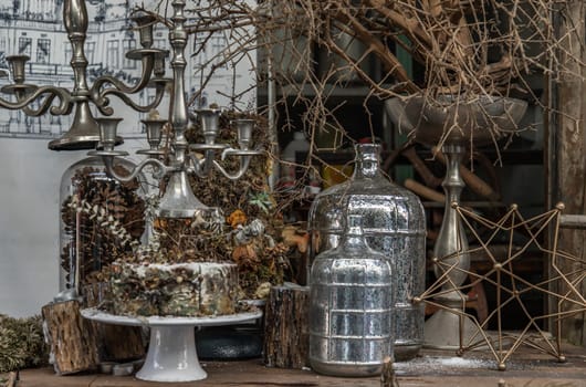 Antique candlestick and Dry plant, Dried flowers, Pine cones with Glass bottle Decorate on wooden table in cafe. Vintage shop decoration idea. Selective focus.