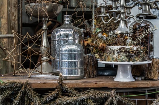 Antique candlestick and Dry plant, Dried flowers, Pine cones with Glass bottle Decorate on wooden table in cafe. Vintage shop decoration idea. Selective focus.