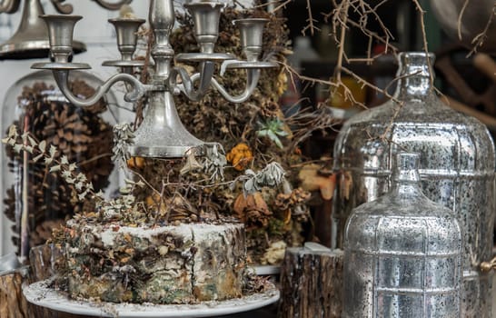 Antique candlestick and Dry plant, Dried flowers, Pine cones with Glass bottle Decorate on wooden table in cafe. Vintage shop decoration idea. Selective focus.