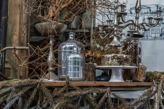Antique candlestick and Dry plant, Dried flowers, Pine cones with Glass bottle Decorate on wooden table in cafe. Vintage shop decoration idea. Selective focus.