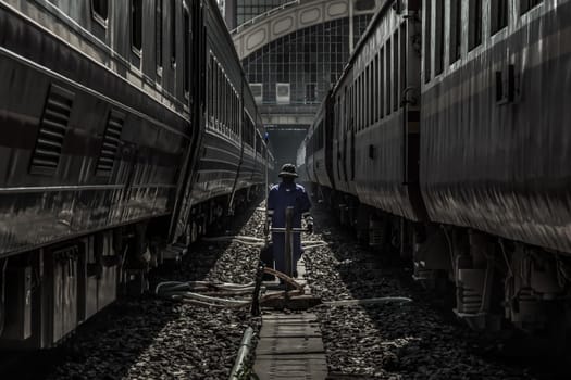 Cleaning staff while cleaning the train at Bangkok Railway Station or Hua Lamphong Railway Station. Focus and blur.