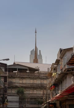City view of Bangkok with House and Modern tall building and Thai temple that perfectly coexist. Selective focus.