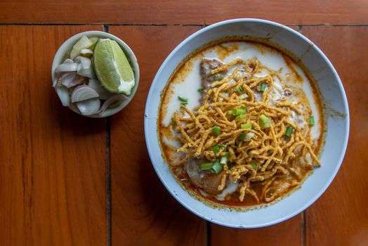 Traditional Khao Soi Recipe, Thai Northern Style Curried Noodle Soup with Chicken in white bowl. Selective focus.