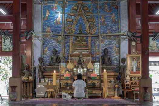 Lampang, Thailand - Sep 03, 2020 : Young woman sitting praying pay respect to Buddha statue at Buddhist temple in Wat Chaloem Phrakiat Phrachomklao Rachanuson at Chae Hom. Selective focus.